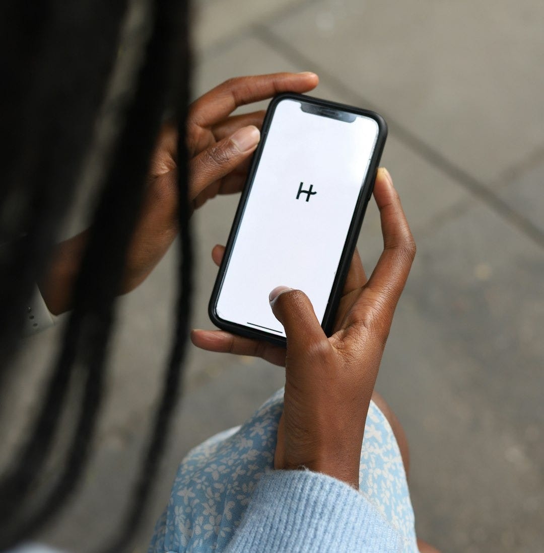 a woman holding a cell phone with a h on the screen