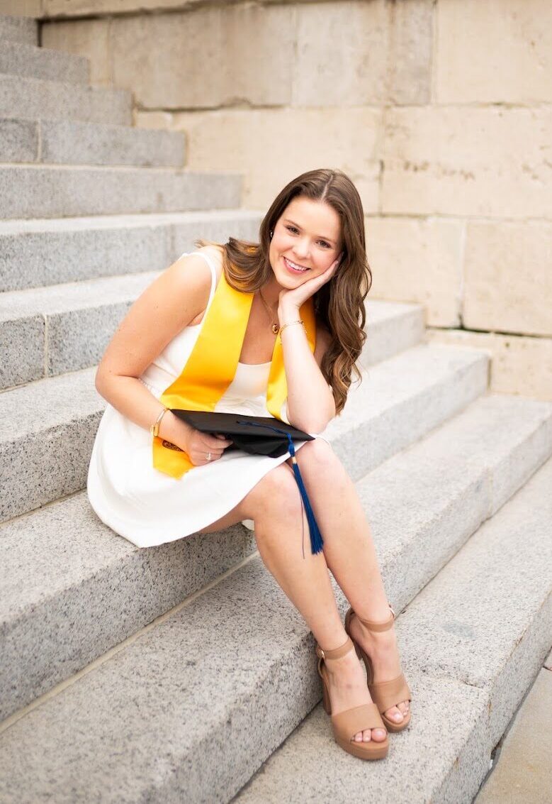 Caroline Potts in her graduation stole on the steps of the University of Iowa Pentacrest